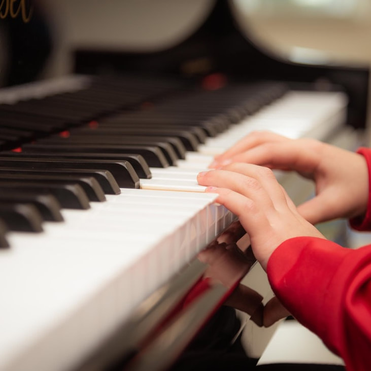 Child gently places hands on piano.